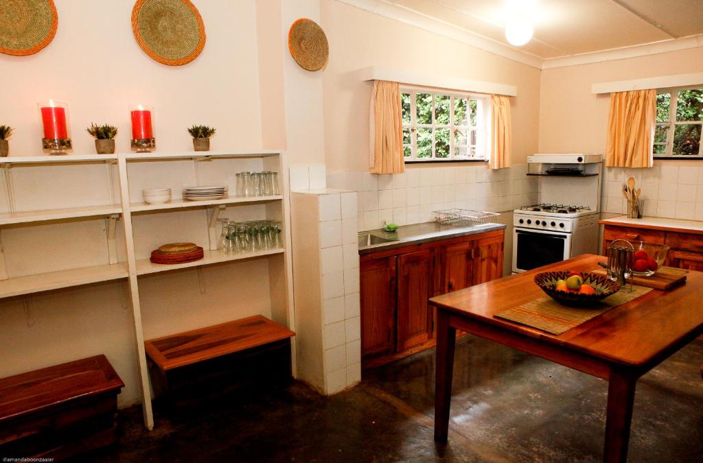 cocina con mesa de madera y mesa de madera sidx sidx sidx sidx en Down Gran's Self-Catering Cottage en Lobamba