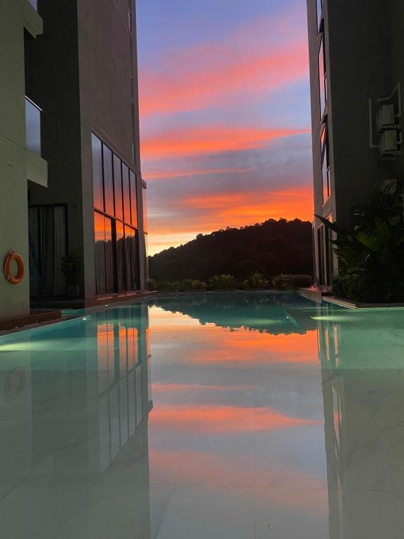 a reflection of a sunset in a swimming pool at Patong Sea View pool view condo in Patong Beach