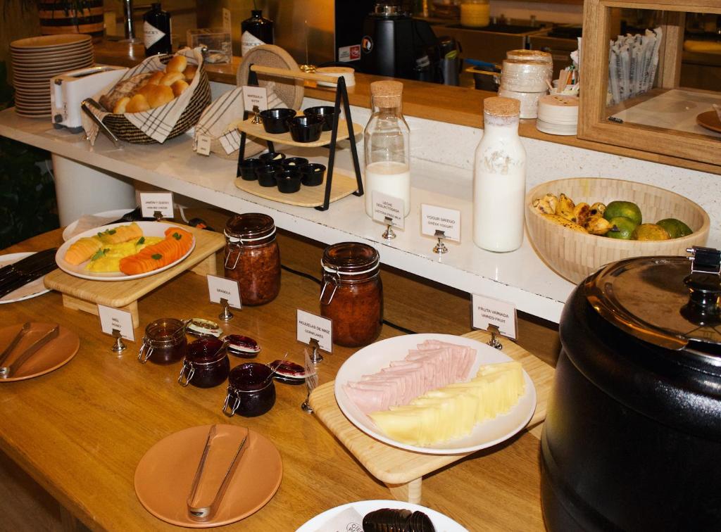 un buffet de comida con pan y otros alimentos en The Somos Central Hotel Poblado, en Medellín