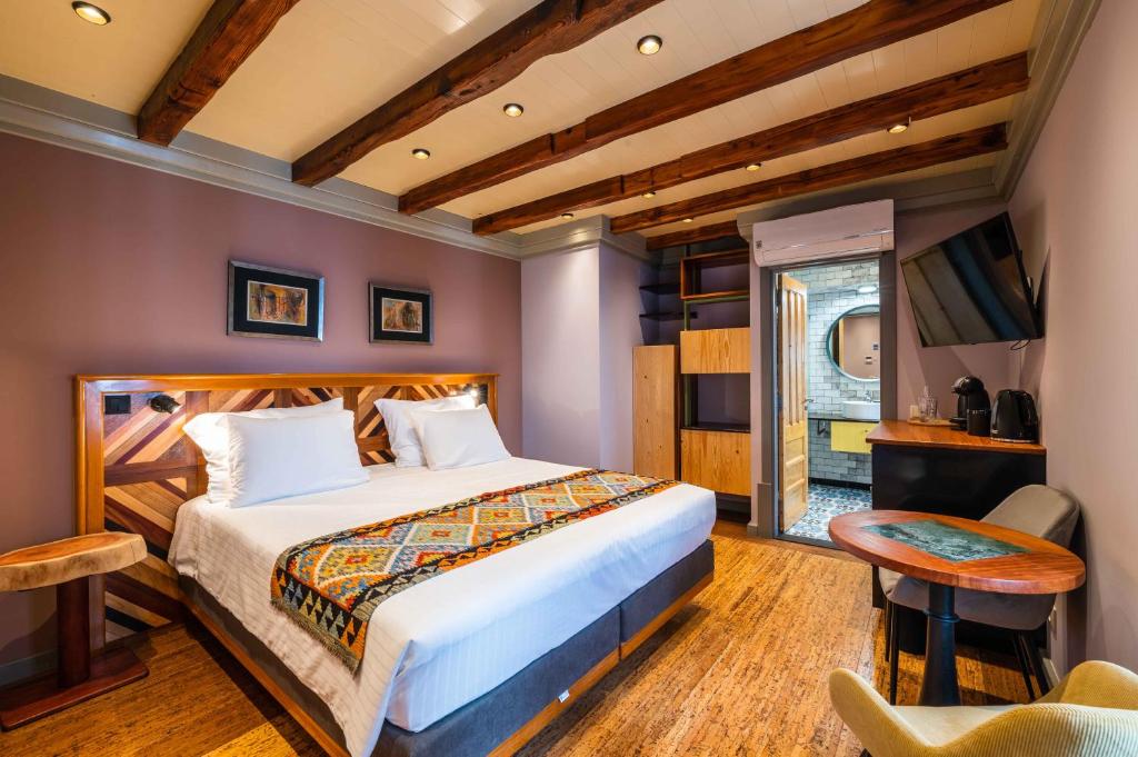 een slaapkamer met een bed, een tafel en een stoel bij Vila Origens Boutique Hotel Albufeira – Adults Only in Albufeira