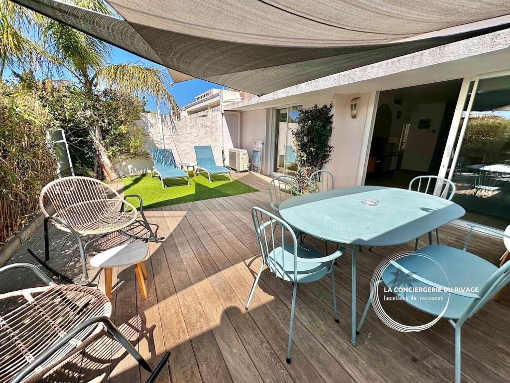 un patio avec une table et des chaises sur une terrasse dans l'établissement Le Malibu - Port de Carqueiranne - Tout à pied, à Carqueiranne
