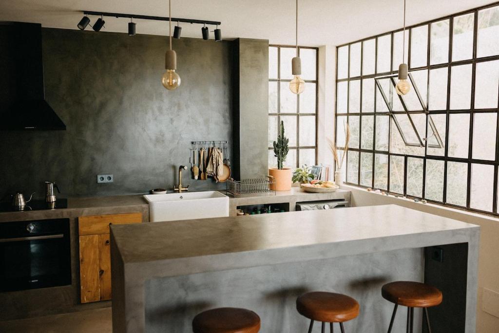 eine Küche mit einer Theke und Hockern darin in der Unterkunft Stylish Loft with Nature Views, Balcony in the heart of Vejer in Vejer de la Frontera