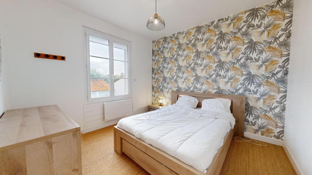 Un dormitorio con una cama y una pared. en Etoile des Mers, en Plage-des-Demoiselles