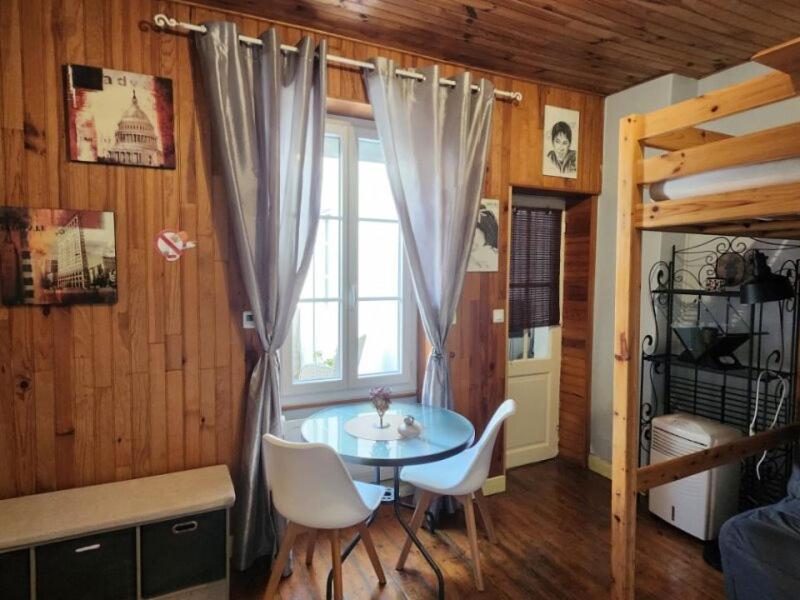 a room with a table and chairs and a window at Logement sympas à Saintes in Saintes