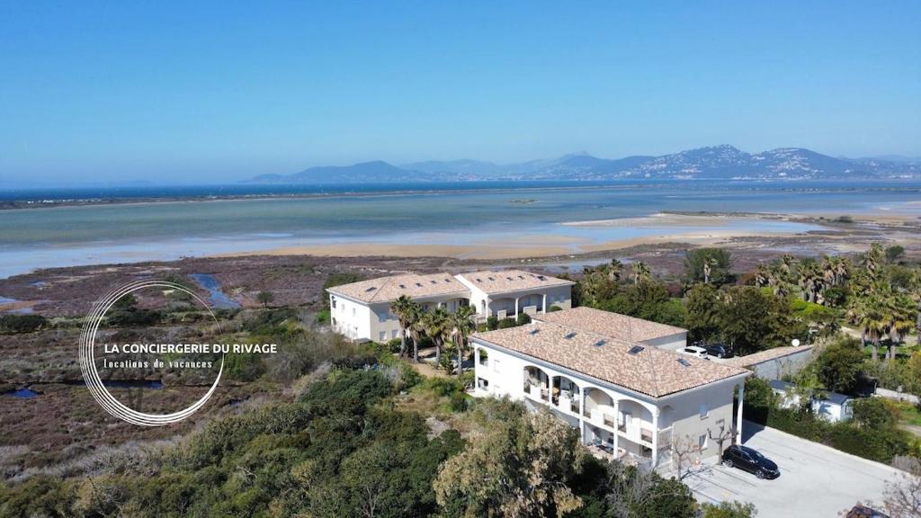 une vue aérienne d'une maison à côté d'un plan d'eau dans l'établissement Les Salins d'Azur - Terrasse - Proche de la plage, à Hyères