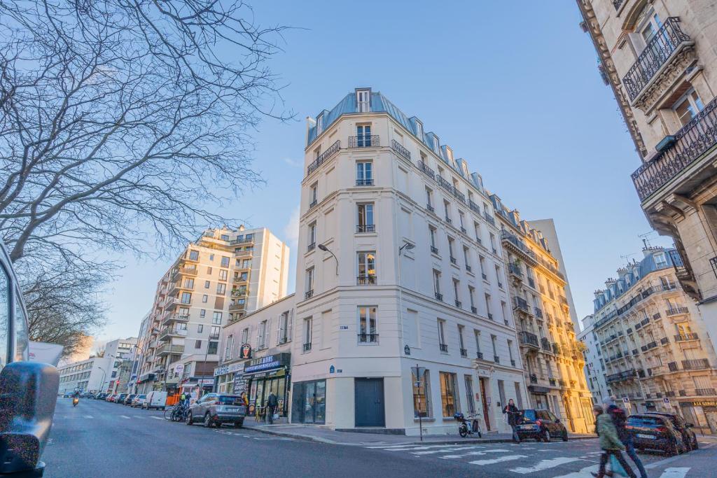 a tall white building on a city street at Résidence Le Belleville in Paris
