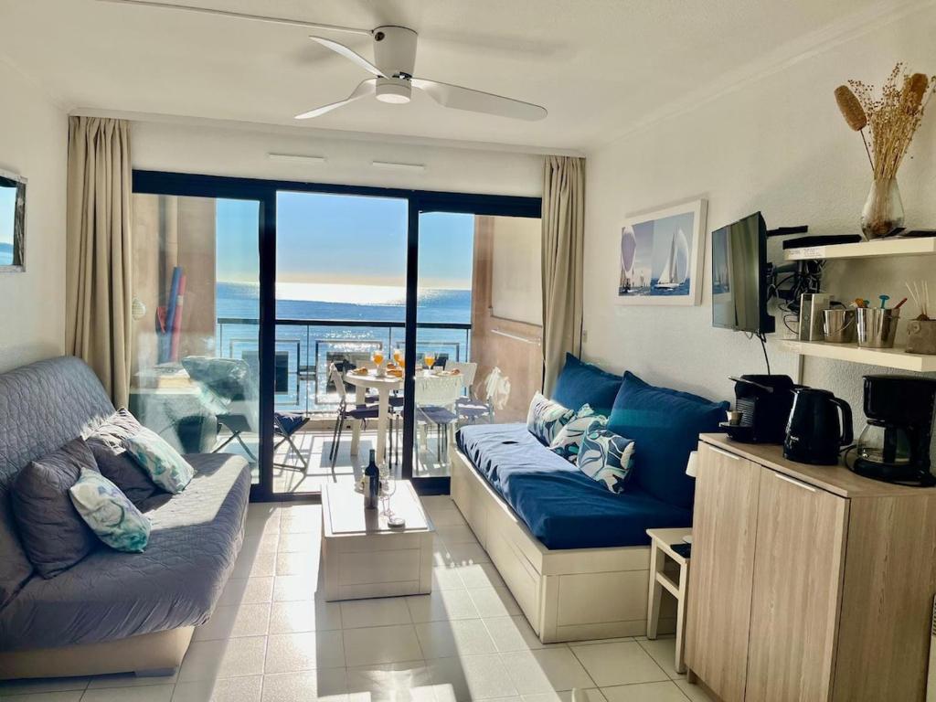 un salon avec un canapé bleu et un balcon dans l'établissement Sun and Sea YourHostHelper, à Cannes