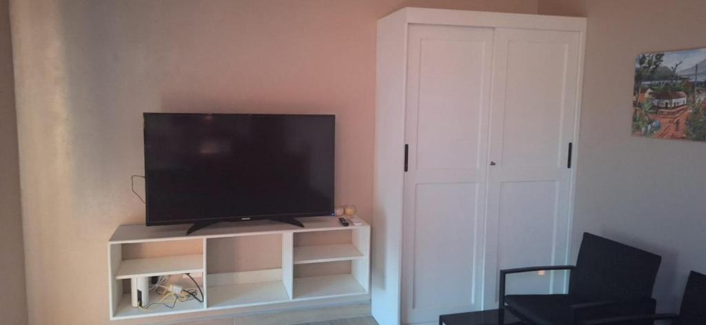 a flat screen tv sitting on a stand in a living room at Tiny Home Villa - T8 in San Diego