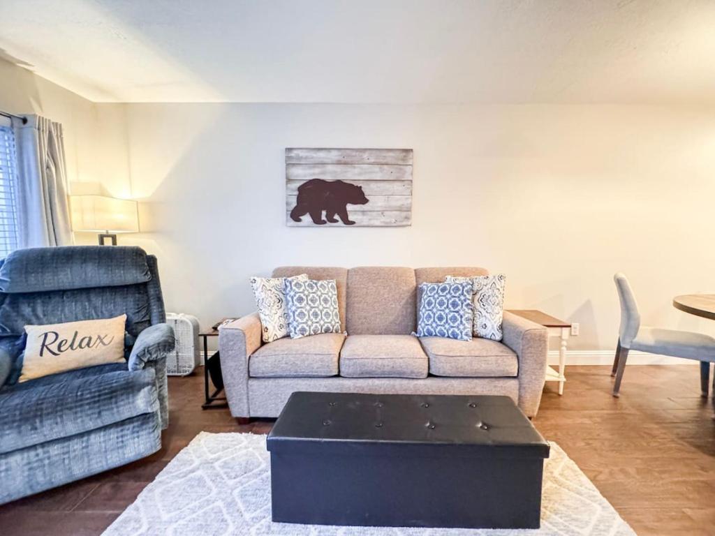 ein Wohnzimmer mit einem Sofa und einem Bärengemälde an der Wand in der Unterkunft Inn Building Condo 107 in Garden City
