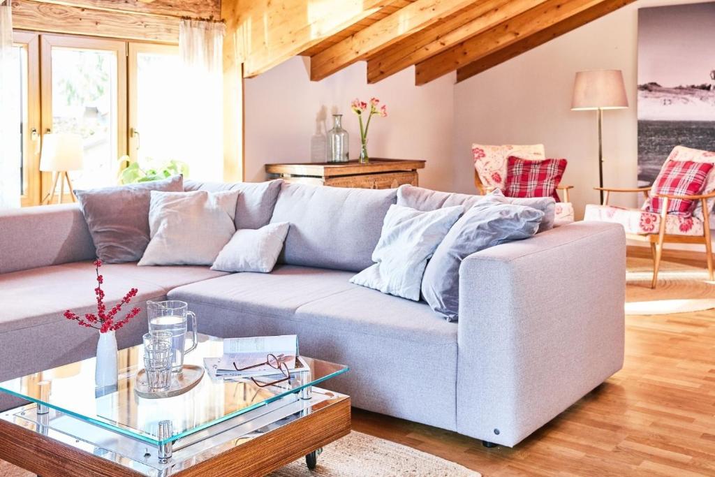 a living room with a couch and a glass table at Übersee21 Ferienloft am Chiemsee in Übersee