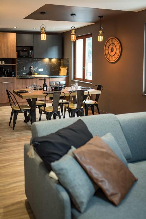 un salon avec un canapé et une table avec des chaises dans l'établissement 4 to 6 people in Orelle direct to 3 Vallées, à Orelle