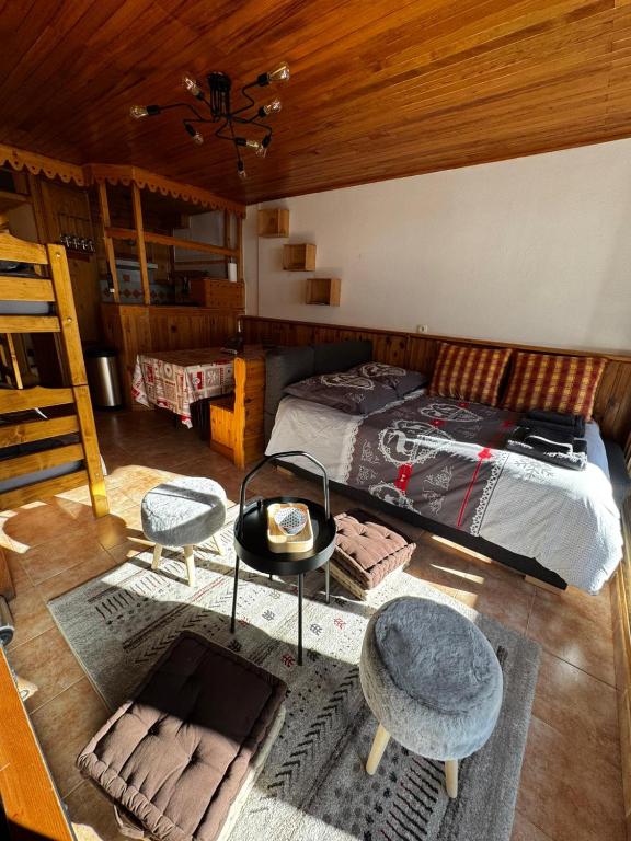 ein Schlafzimmer mit einem Bett und zwei Stühlen und einem Tisch in der Unterkunft Studio cosy à 5 min à pied des pistes in La Salle Les Alpes
