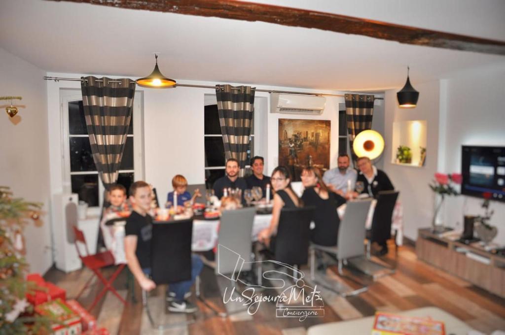 un groupe de personnes assises autour d'une table dans l'établissement UnSejourAMetz - LeGrandJeu - 14 pers - 4 garages, à Metz