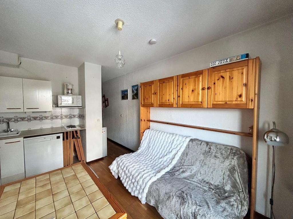 a bedroom with a bed and a kitchen at Appartement Arêches in Beaufort