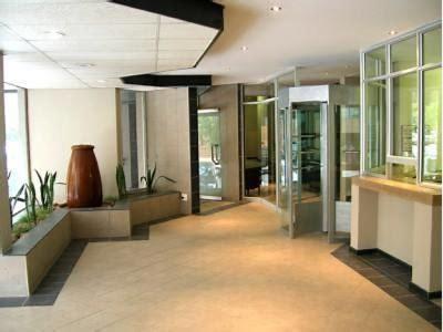 un vestíbulo vacío de un edificio de oficinas con puertas de cristal en 50 stiemens street, en Johannesburgo