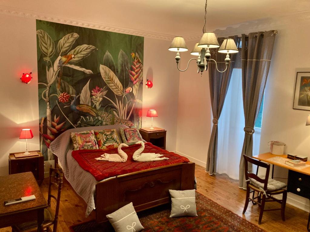 Un dormitorio con una cama con un cuadro en la pared. en La Maison Marguerite, en Herrère