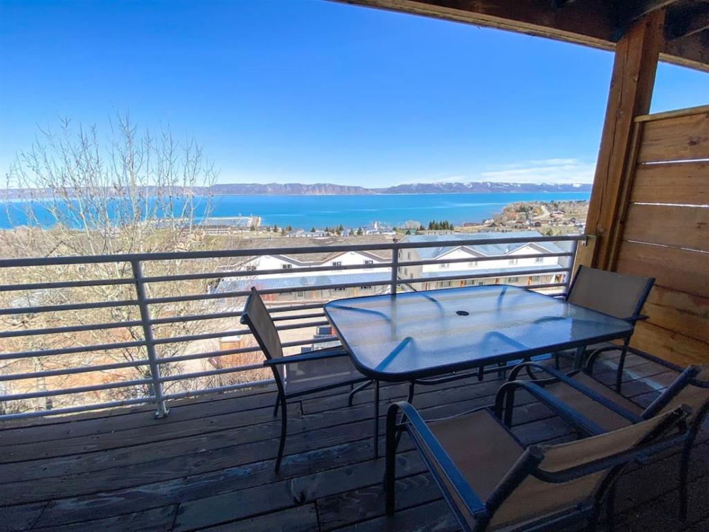 a table and chairs on a porch with a view of the water at Updated Lake View Condo 941 2- Amazing Views in Garden City