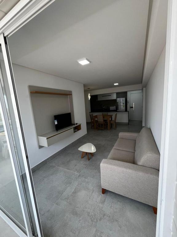 un soggiorno con un divano e un tavolo di APARTAMENTO EM CAMBOINHA PARA TEMPORADA EM JOÃO PESSOA, A 100M DO MAR E DE FRENTE A AREIA VERMELHAa a Cabedelo