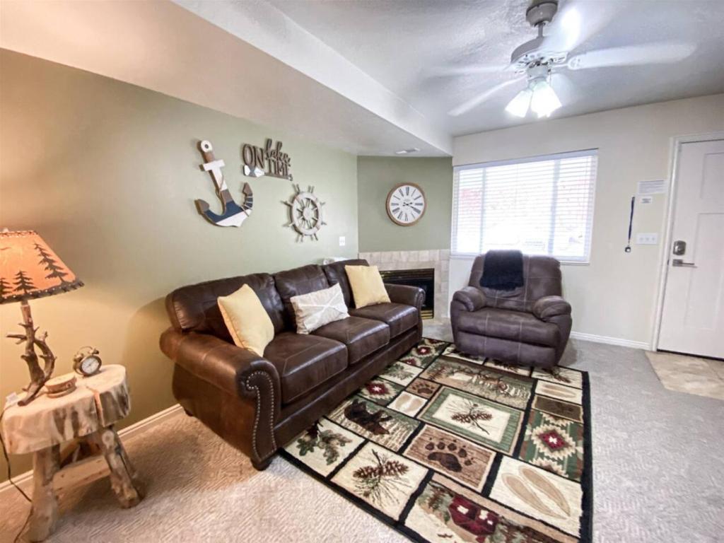 a living room with a leather couch and two chairs at Lake View Condo 930 2 in Garden City