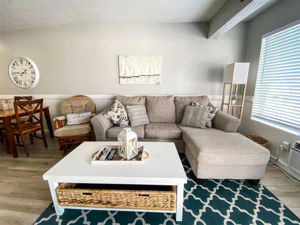 加登城Inn Building Condo 203, Remolded with Lake View的客厅里有一张沙发和一张桌子。