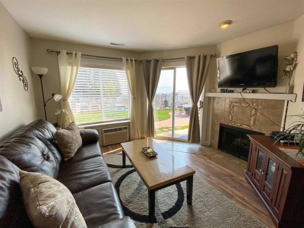 a living room with a leather couch and a table at Inn Building Condo 103 updated, pool side view in Garden City