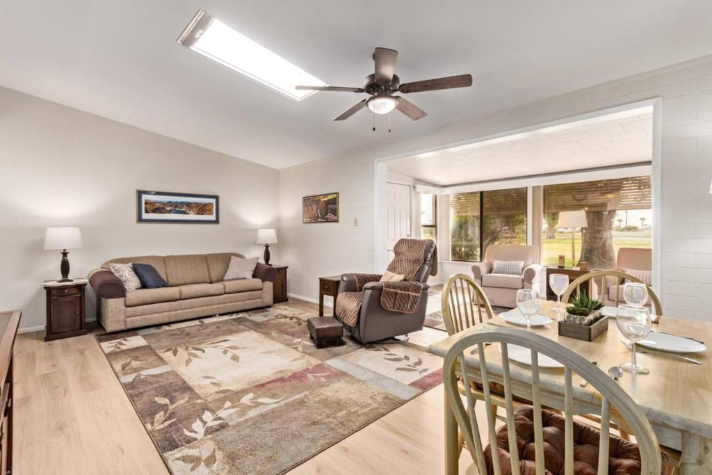 a living room with a ceiling fan and a table at Relaxing 2BR plus Den Golf Retreat with Backyard and BBQ in Sun City
