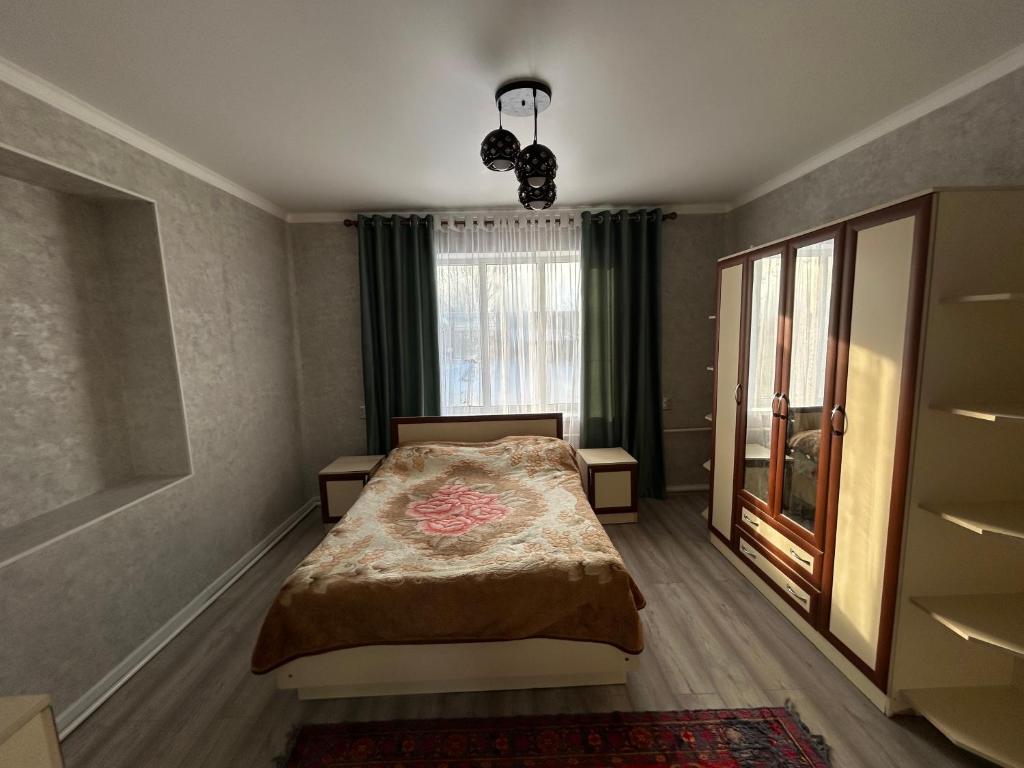 una camera da letto con un letto e una finestra di Privat House a Karakol