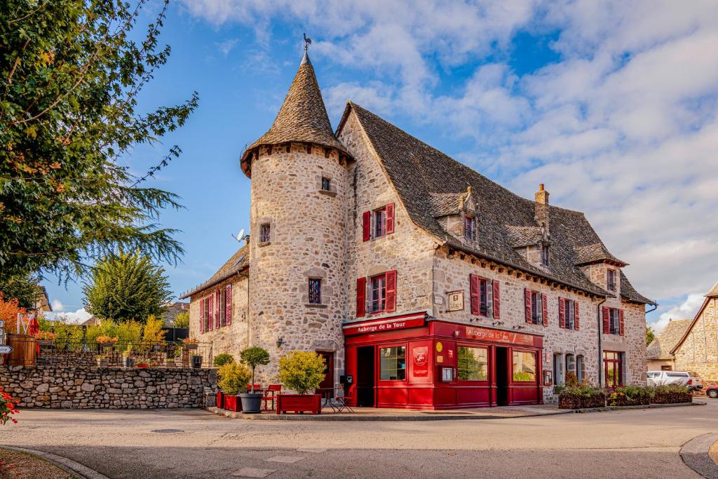 ein großes Steingebäude mit einem Turm in der Unterkunft Demeures & Châteaux Auberge de la Tour - Hôtel & Restaurants - Marcolès Auvergne in Marcolès
