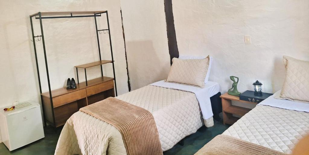 a room with two beds and a mirror at Pousada Mãe Terra in Torrinha