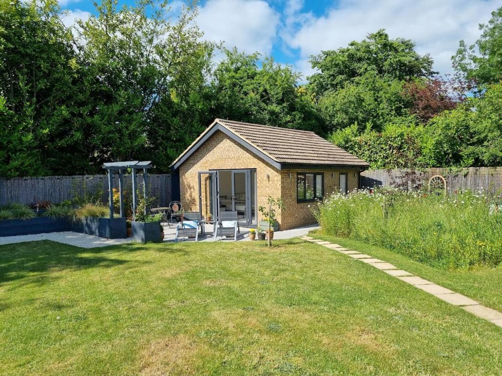 a small house in a yard with a garden at The Garden Room in Henley on Thames