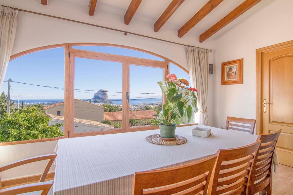 ein Esszimmer mit einem Tisch und einem großen Fenster in der Unterkunft Casa con vistas al Mar en Calpe - Cucarres in Calpe