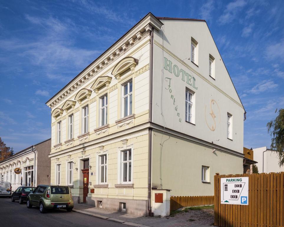 a white building with a sign on the side of it at Pension Fontána Svitavy in Svitavy