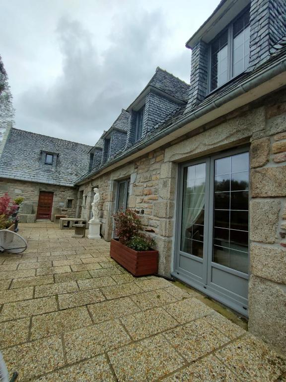 une maison en pierre avec une grande porte coulissante en verre dans l'établissement La montagnarde, à Huelgoat