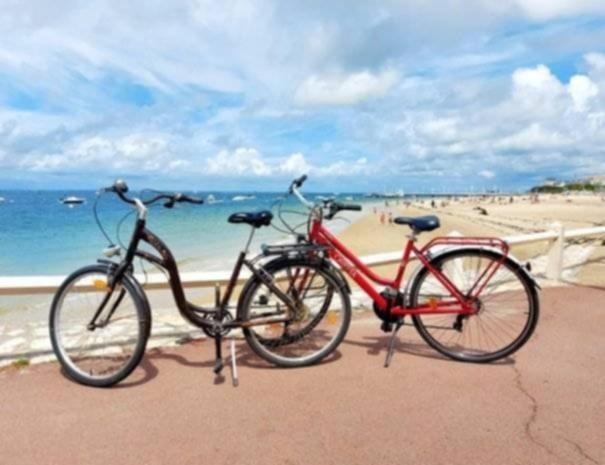 Deux vélos sont garés à côté de la plage. dans l'établissement Appartement Arcachon, à Arcachon