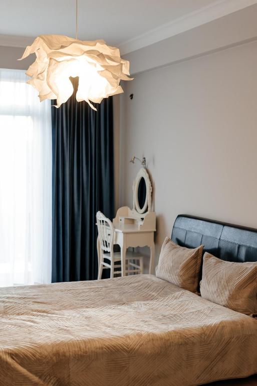 a bedroom with a bed and a table with a chair at City Walk Apartment & MiRent in Chişinău