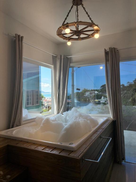 a large bath tub in a room with a window at Jacuzzi Privativa e Vista Mar - Apto Remo in Florianópolis