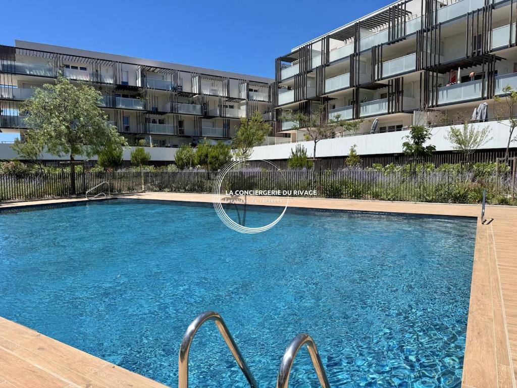 - une piscine en face d'un immeuble dans l'établissement Le Rivage - À 50m de la plage des Salins - Piscine, à Hyères