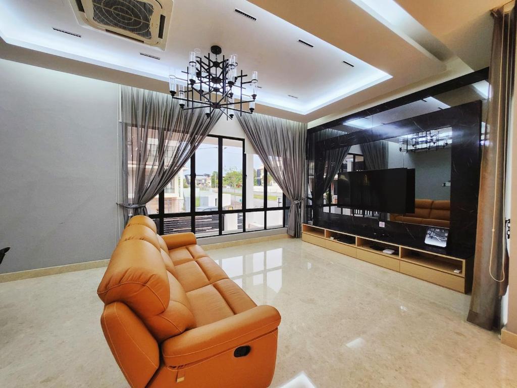 a living room with a couch and a television at Ipoh Botani Nardine luxury semi d 5br5bath19pax in Ipoh