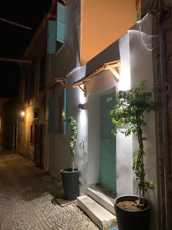 a building with two potted plants in front of a door at Old Town Retreat in Rhodes Town