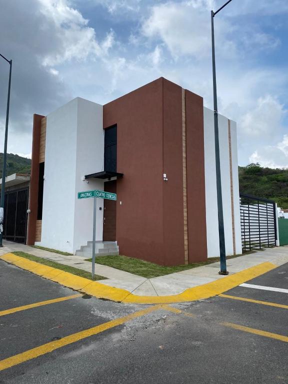a brown and white building with a street sign in front at Casa Puerta Paraíso in Tepic