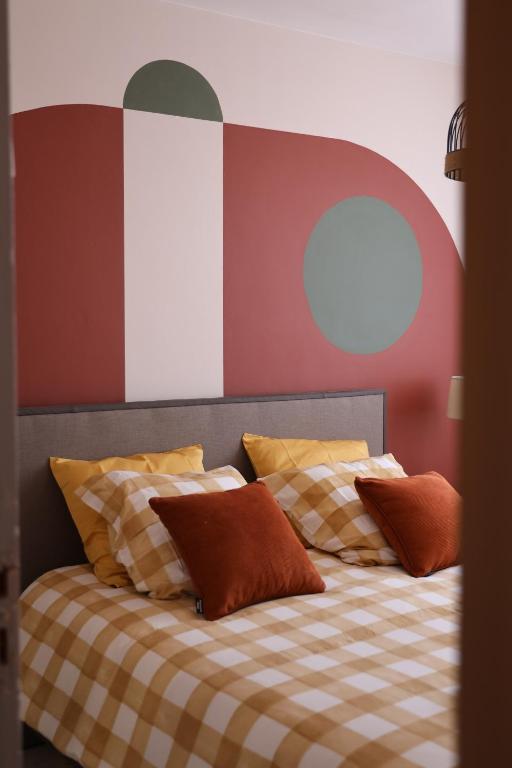 - un lit avec une couverture et des oreillers en damier dans l'établissement Le Planol - Maison avec jardin et terrasse, à Alzonne