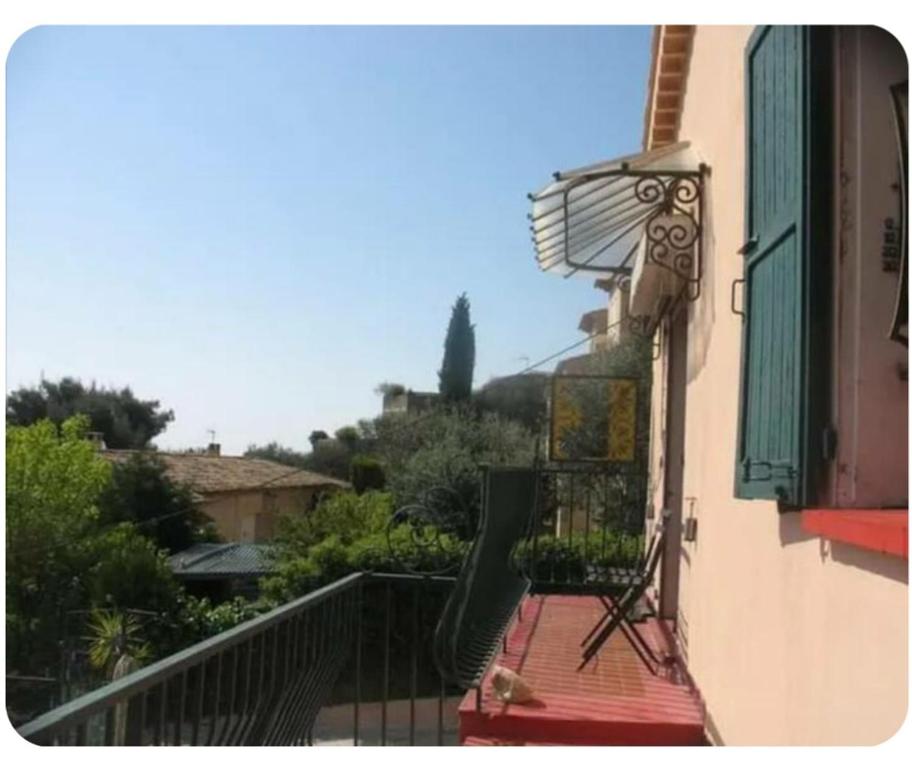 a balcony of a building with a green shutter at Chambre au calme sur les collines in Nice