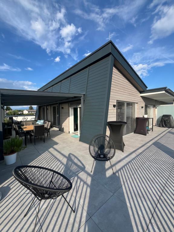 a patio with two chairs and a table and a building at LUX PENTHOUSE Klopeiner See Apartment Ferienwohnung FeWo in Sankt Kanzian