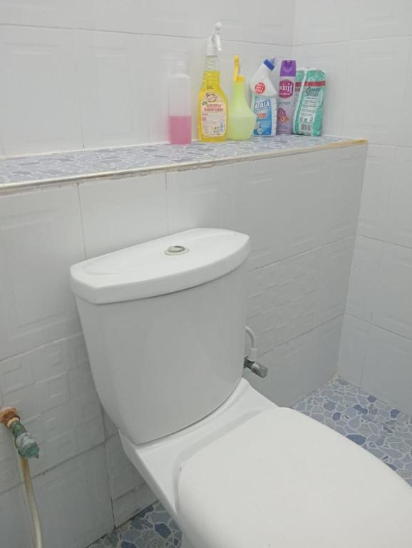 Un baño con inodoro blanco y algunos productos de limpieza. en The Cozy Cove, en Mombasa