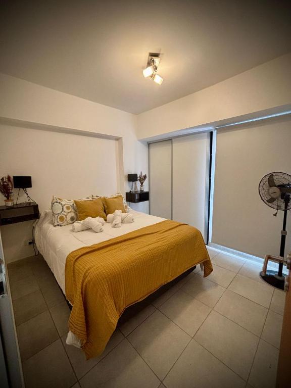 a bedroom with a large bed with a yellow blanket at Alsina - Central Point Apartments in Salta