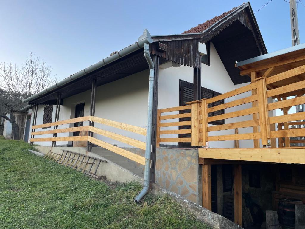 a house with a wooden fence on the side of it at Aranyodi hegyi hajlék in Zalaszentgrót