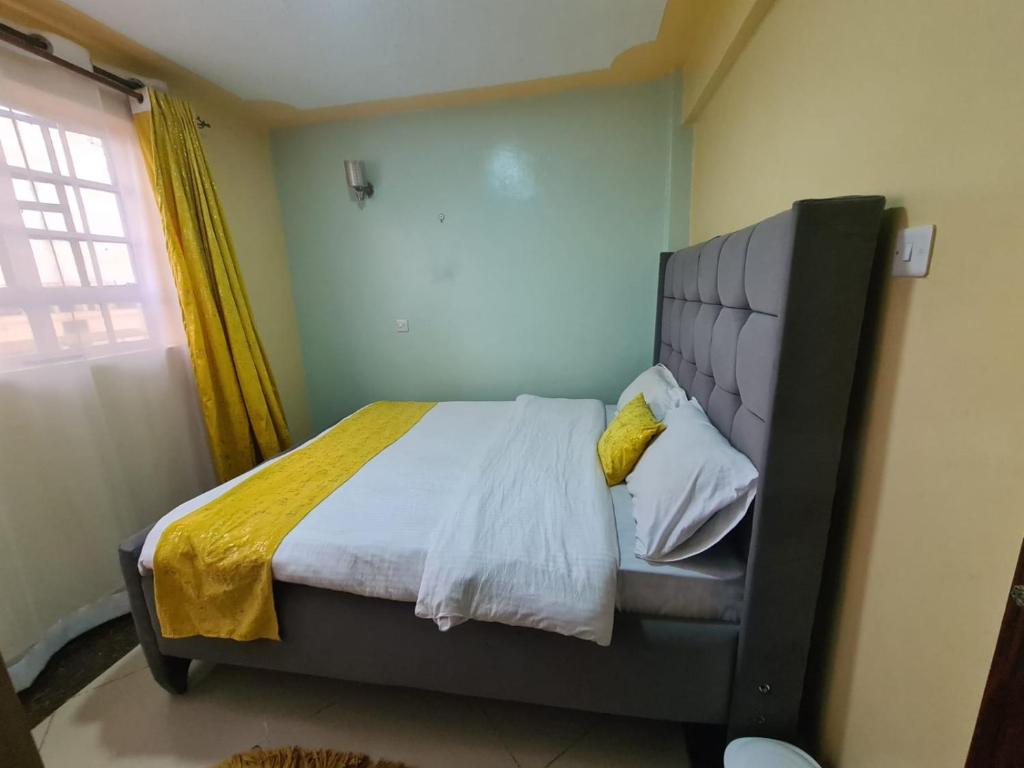 a bedroom with a bed in a room with a window at Very demure one bedroom with free parking in Nairobi