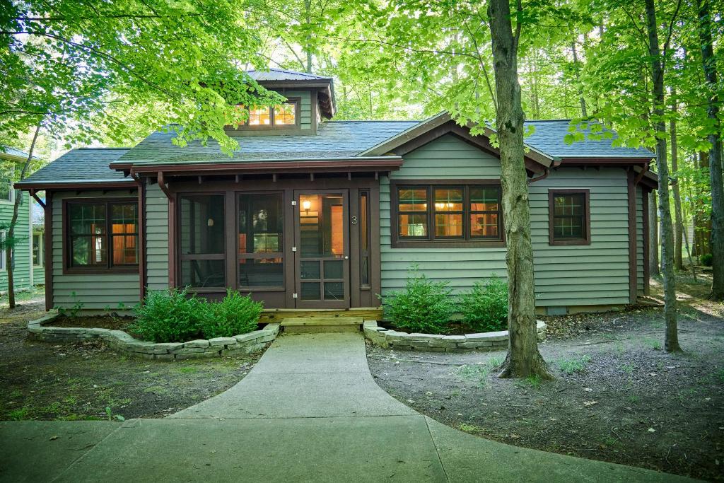 una pequeña casa verde con porche y árboles en Dollybrook 3 Pet Friendly Community Pool Groups Welcome, en Fennville