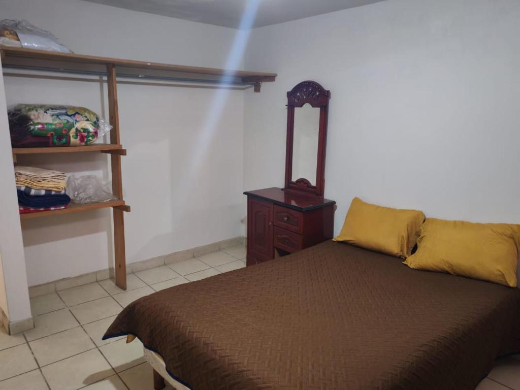 a bedroom with a bed and a wooden dresser at Casa de tres habitaciones por infonavit constituyentes in Uruapan del Progreso