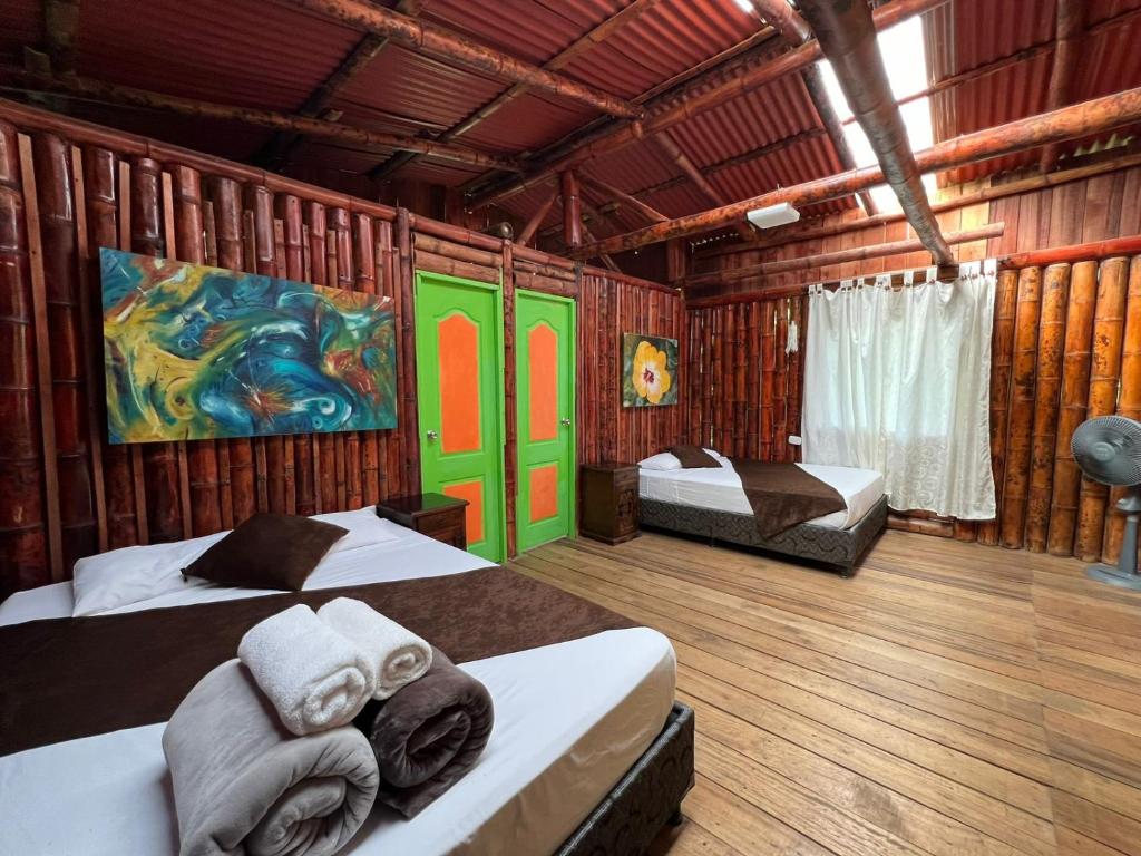 a bedroom with two beds and a painting on the wall at Eco Hotel Green Eden in Pereira